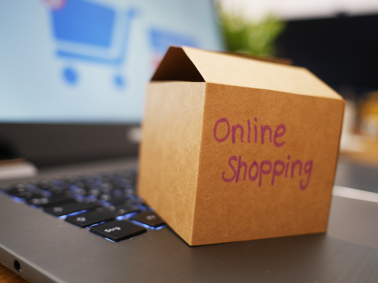 Kleiner Karton mit der Aufschrift Online Shopping auf einer Laptop-Tastatur